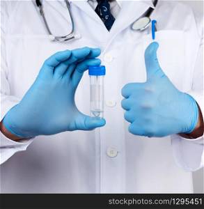 doctor in a white coat and blue sterile latex gloves holds a plastic jar for stool analysis, white background