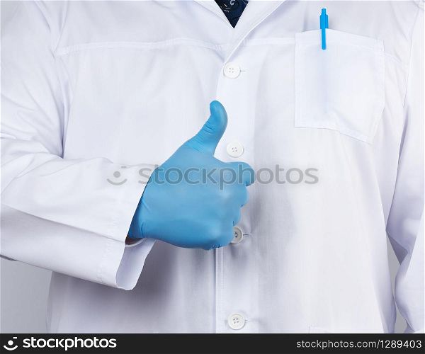 doctor in a white coat and tie shows with his hand a gesture like, wearing blue latex medical gloves, close up