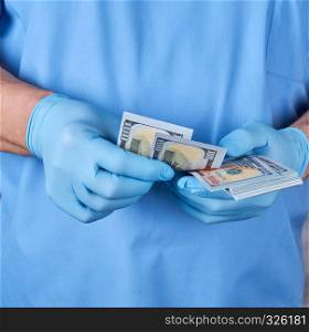 doctor in blue uniform and gloves recounts money, the concept of giving take for medical services