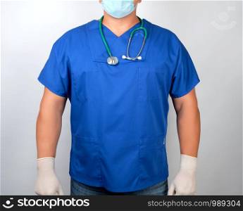 doctor in blue uniform and latex gloves, stethoscope hanging on his neck, white background