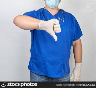 doctor in blue uniform and white latex sterile gloves shows a gesture is bad or dislike, concept of bad evaluation of something
