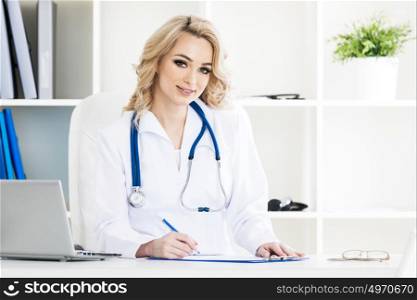 Doctor in clinical office. Portrait of smiling beautiful female doctor in a clinical office