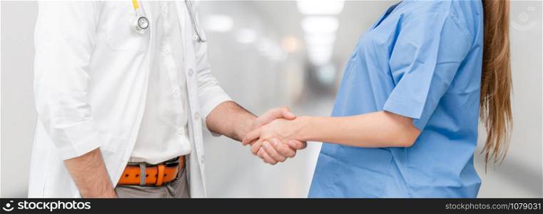 Doctor in hospital handshake with another doctor. Healthcare people teamwork and medical service concept.