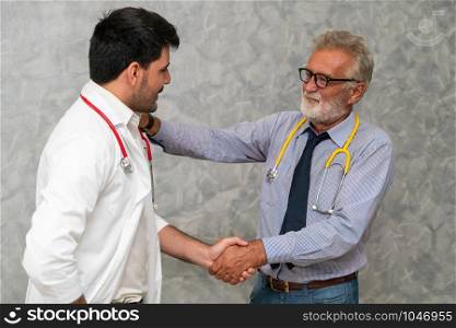 Doctor in hospital handshake with another doctor. Healthcare people teamwork and medical staff service concept.