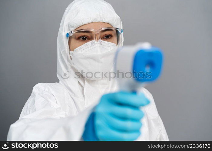 doctor in protective PPE suit scanning with infrared thermometer, IR Thermoscan