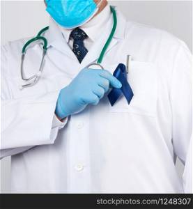 doctor in white uniform and sterile latex gloves holds a dark blue ribbon, concept of timely research and disease prevention colon malignancies, chronic fatigue syndrome, tuberous sclerosis