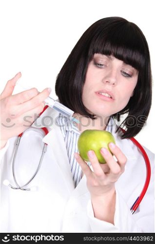Doctor injecting an apple