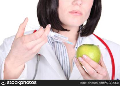 Doctor injecting drugs into apple