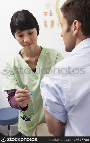Doctor injecting male patient in hospital