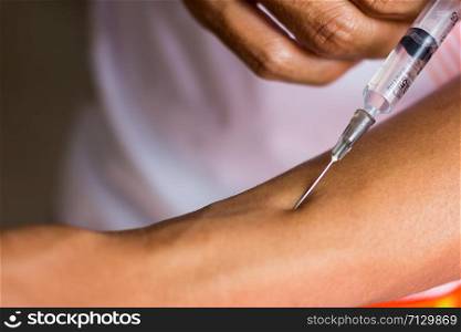Doctor Injecting Patient With Syringe To Collect Blood On White Background