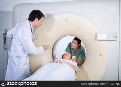 Doctor instructing technician while preparing patient for MRI scan
