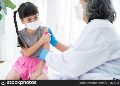 Doctor is affixing the medicinal plaster after vaccinated in shoulder of Asian girl kids in hospital. Pediatrician makes vaccination for kids. Vaccination, immunization, disease prevention concept.