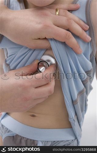 Doctor is listening to the heart rhythm of a little boy with a stethoscope