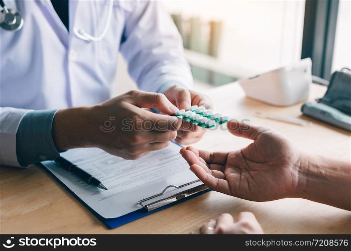 Doctor is pointing to drug tablet and introducing the properties of the painkiller to patient at office.