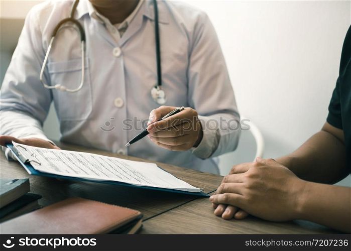 Doctor is writing the appointment letter to the patient at the clinic.