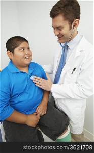 Doctor listning to boy&acute;s heartbeat