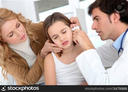Doctor looking at little girl ear infection