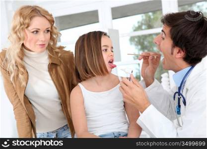 Doctor looking at sick little girl throat