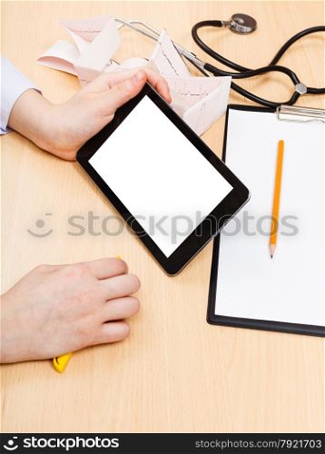 doctor looks on tablet pc with cut out screen during appointment