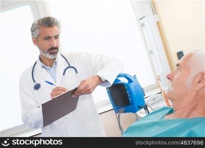 doctor making anamnesis with senior patient lying