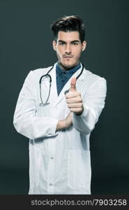 Doctor making positive thumb gesture over grey background