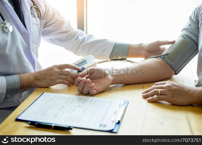 Doctor measuring and checking blood pressure of patient in hospital, Health care concept