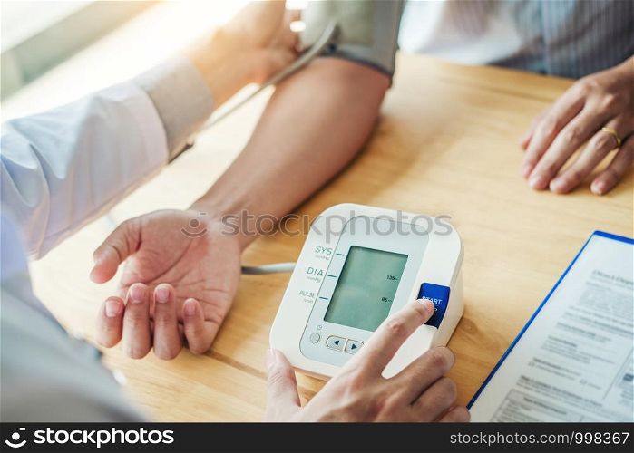 Doctor Measuring arterial blood pressure man patient on arm Health care in hospital