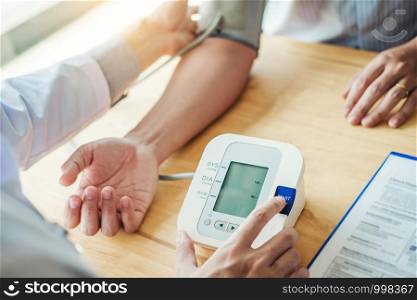 Doctor Measuring arterial blood pressure man patient on arm Health care in hospital