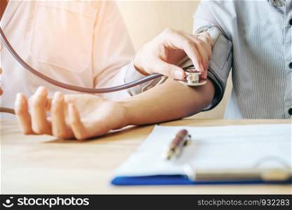 Doctor Measuring arterial blood pressure woman patient on right arm Health care in hospital