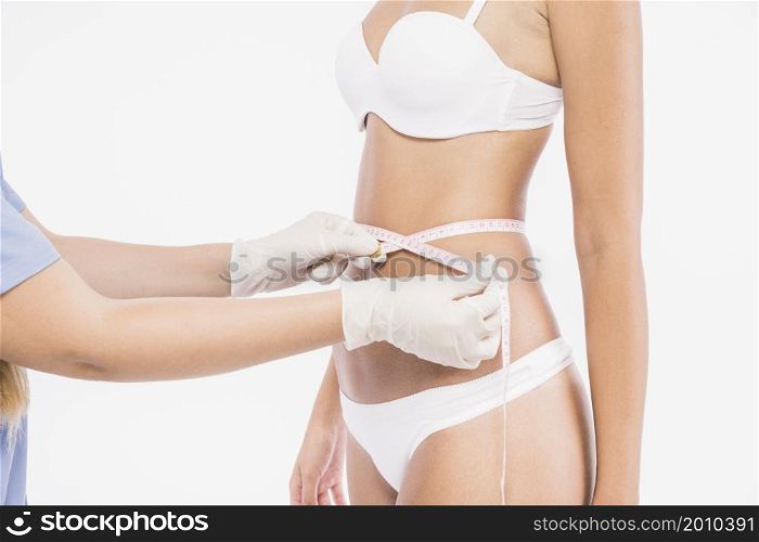 doctor measuring woman waist