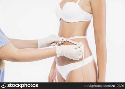 doctor measuring woman waist