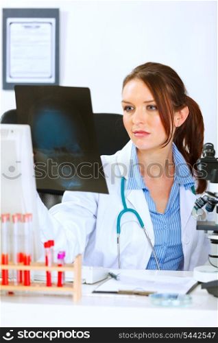 Doctor medical woman sitting at office table and analyzing patients roentgen&#xA;