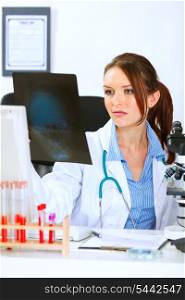 Doctor medical woman sitting at office table and analyzing patients roentgen&#xA;