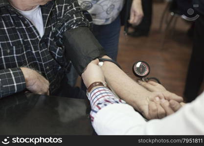 Doctor/nurse checking senior men blood pressure