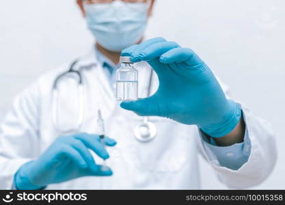 Doctor, nurse, scientist hand in blue gloves holding flu, measles, coronavirus, covid-19 vaccine disease preparing vaccination shot, medicine and drug concept.