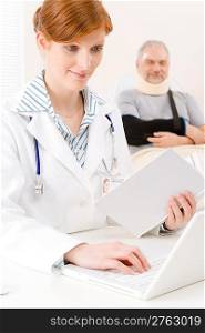 Doctor office - portrait female physician look up book senior patient
