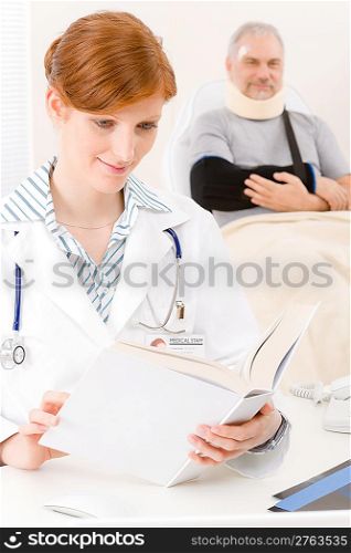 Doctor office - portrait female physician read book senior patient