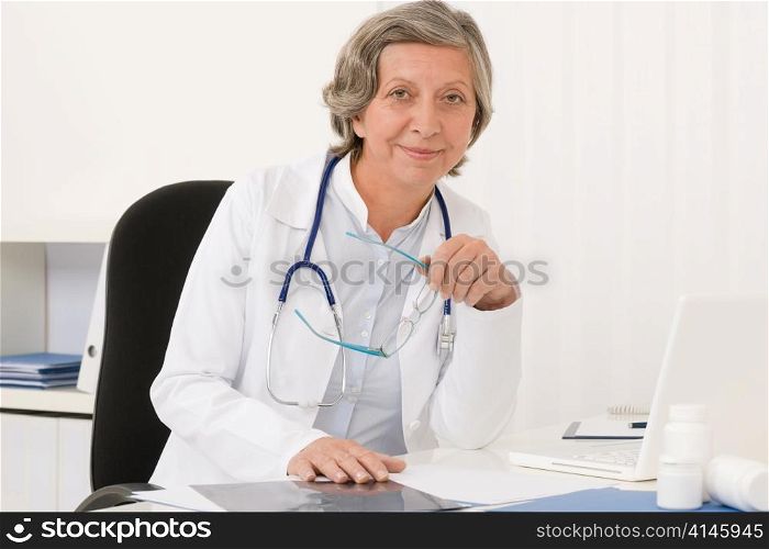 Doctor office - senior female physician work computer sit behind desk