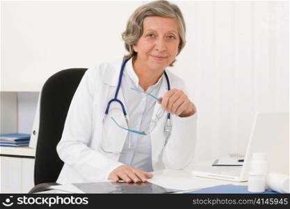 Doctor office - senior female physician work computer sit behind desk