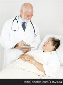 Doctor on his rounds, talking to a patient in the hospital.