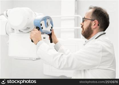 Doctor operating X-ray machine in radiology department. High quality photography.. Doctor operating X-ray machine in radiology department