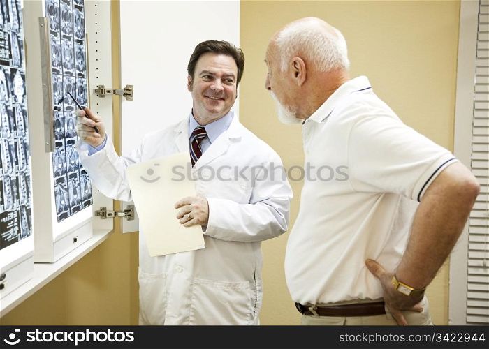 Doctor or chiropractor explaining the results of a CT scan of the spine to his patient suffering with low back pain.