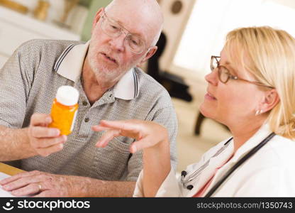 Doctor or Nurse Explaining Prescription Medicine to Attentive Senior Man.