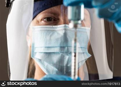 Doctor or Nurse Wearing Surgical Gloves Holding Vaccine Vial and Medical Syringe.
