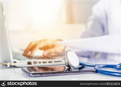 Doctor or nurse woman in uniform with stethoscope working she typing information of patient prescription from paperwork medical history form into laptop computer for record document data report