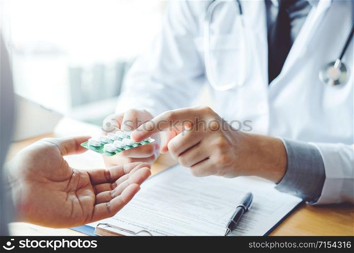 Doctor or physician recommend pills medical prescription to male Patient hospital and medicine concept