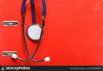doctor or physicians stethoscope on red background