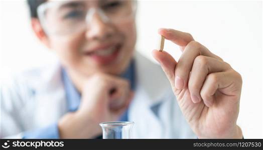 Doctor or scientist holding medicine pill in pharmaceutical lab. Concept of medical technology research and development for future cure of illness.