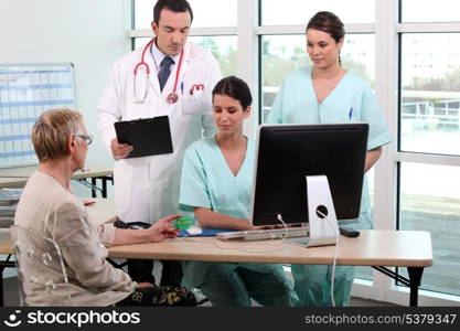 Doctor, patient, and medical secretaries at reception