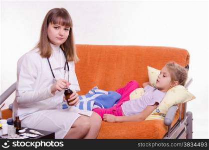 Doctor pediatrician examines a sick child at home